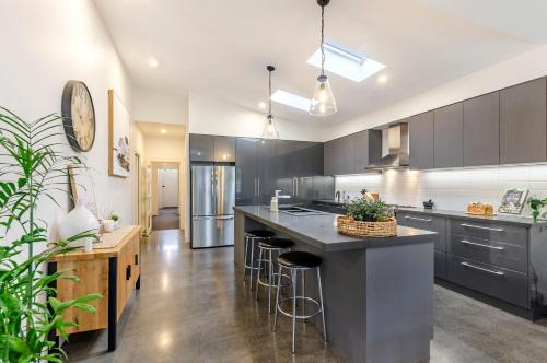 a kitchen with a large island with bar stools at Dianas Place in Warrnambool