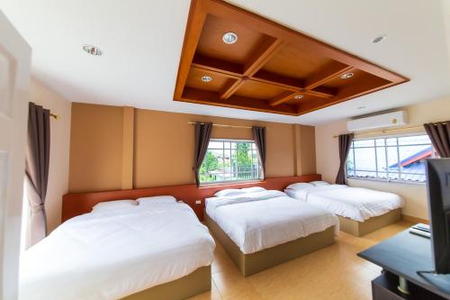 a bedroom with three beds and a flat screen tv at Landara Private Pool Villa Sattahip in Sattahip