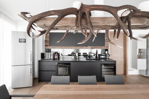 cocina con encimera negra y mesa con sillas en Planai Penthouse Royal, en Schladming