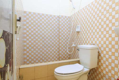 La salle de bains est pourvue d'une douche et de toilettes. dans l'établissement Golden Sunrise Hotel I by RedDoorz, 