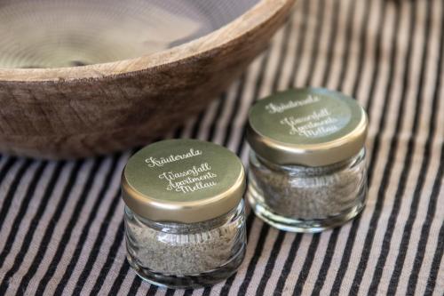 three small glass jars of salt next to a bowl at Wasserfall Apartments Mellau in Mellau