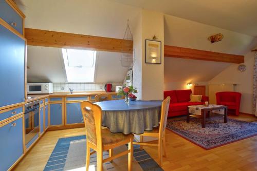 a kitchen and living room with a table and a couch at Beim Rieder in Truchtlaching