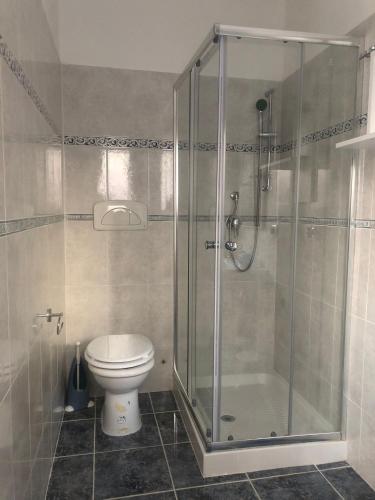a bathroom with a toilet and a glass shower at Casa Sofia in Marconia