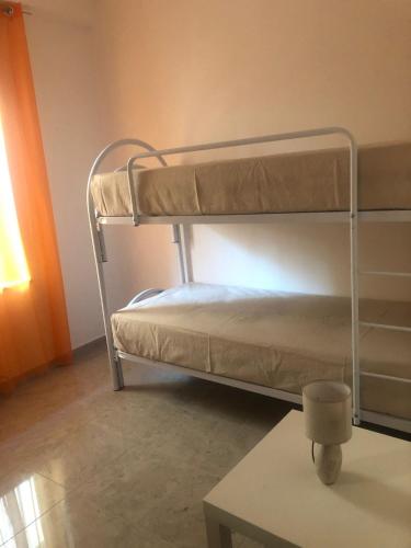 a bunk bed in a room with a table at Casa Sofia in Marconia