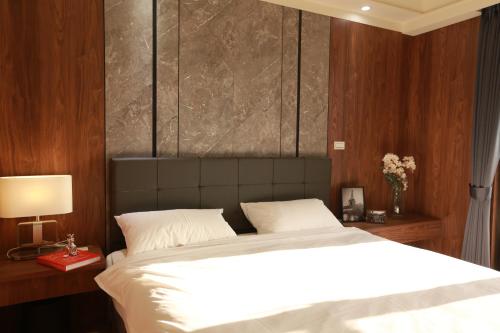 a bedroom with a large white bed with wooden walls at Lin House in Checheng
