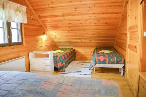 een slaapkamer met 2 bedden in een houten hut bij Pohjantilan Hirsituvat - Pohjantähti in Kontiolahti