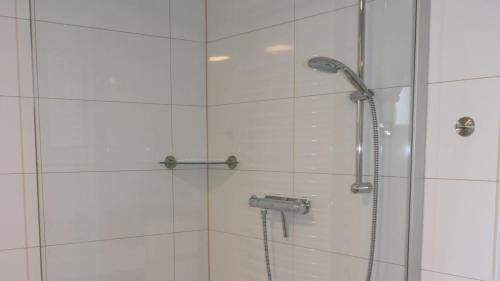 La salle de bains est pourvue d'une douche avec une porte en verre. dans l'établissement Glockenturmblick, à Sankt-Andreasberg