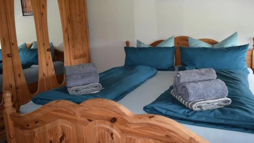 - une chambre avec un lit et des oreillers bleus dans l'établissement Glockenturmblick, à Sankt-Andreasberg