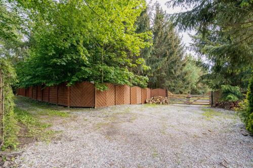 a fence in the middle of a yard with trees at White & Black in Kołczewo