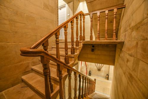 a wooden spiral staircase in a home with a stair case at The Bheemgarh in Jaisalmer