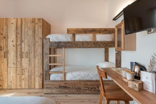 a room with two bunk beds and a desk at Agritur Maso Librar in Trento