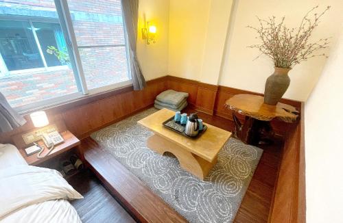 a room with a table and a bed and a vase at Chinshan Villa in Zhongzheng
