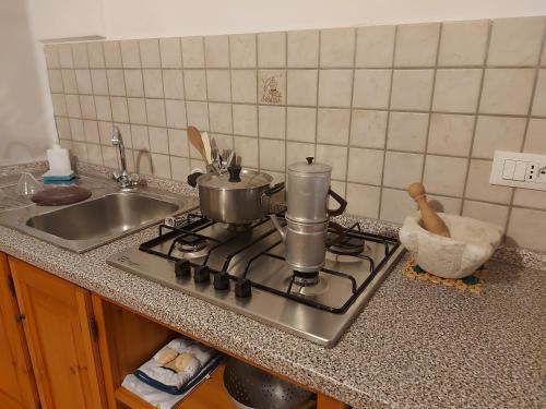 a kitchen stove with pots and pans on it at sax & rosa in Pigna