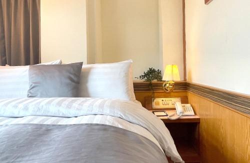 a bedroom with a bed and a phone on a table at Chinshan Villa in Zhongzheng