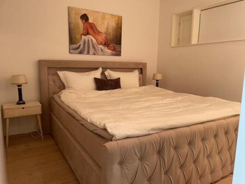 łóżko w sypialni z obrazem na ścianie w obiekcie Exclusive apartment, sea view to Oslo fjord, located on water in Oslo center w Oslo