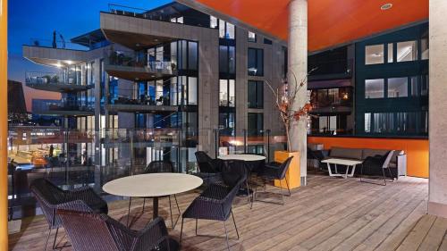 balkon ze stołami i krzesłami oraz budynek w obiekcie Exclusive apartment, sea view to Oslo fjord, located on water in Oslo center w Oslo