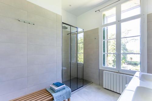 a white bathroom with a shower and a window at Château de Saü in Thuir