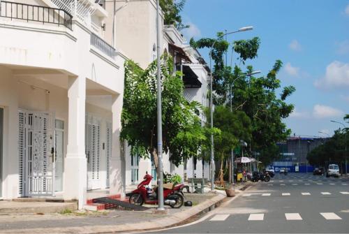 a red motorcycle parked next to a white building at Nina homestay P1,P4 in Ap My Quo