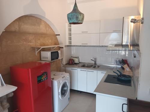 a kitchen with a red refrigerator and a washing machine at La Castillita - Port de Soller Seaview Apartment - Perfect for Couples in Port de Soller