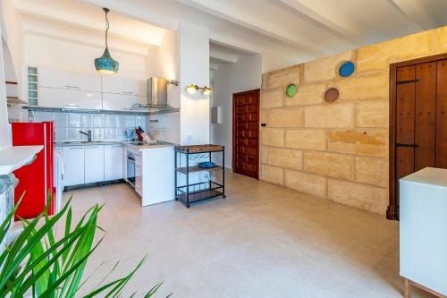 a kitchen with white counters and a brick wall at La Castillita - Port de Soller Seaview Apartment - Perfect for Couples in Port de Soller