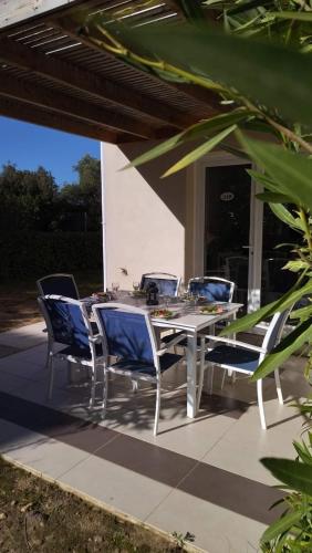 una mesa y sillas en un patio en Maison duplex 2 chambres, avec jardin, 800m plage, en Belgodère