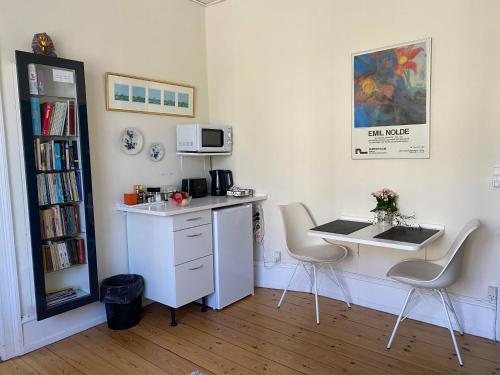 a kitchen with a desk and a table and chairs at Villa Plana in Copenhagen