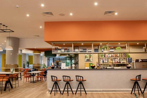 a bar in a restaurant with chairs and tables at Belstay Milano Assago in Assago