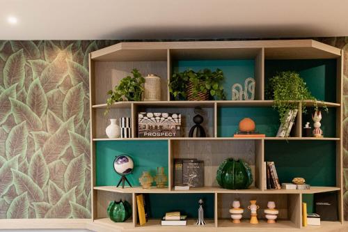 a book shelf with plants and other items on it at Belstay Milano Assago in Assago