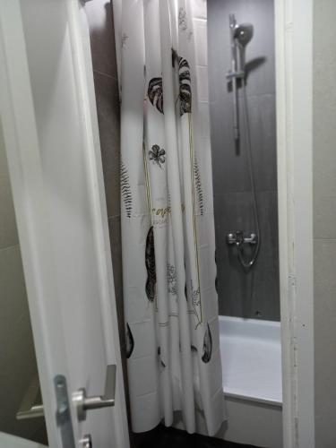 a shower curtain with a spider on it next to a tub at Apartmani Dubrava 3 in Zagreb