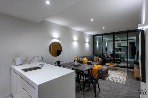 a kitchen and living room with a table and a couch at Mega Style Apartments Flinders St in Melbourne