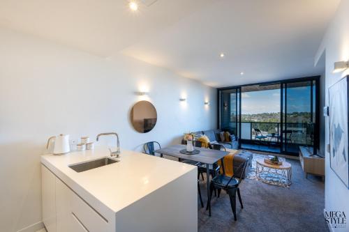 a kitchen and living room with a table and a couch at Mega Style Apartments Flinders St in Melbourne