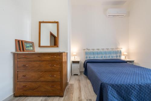 a bedroom with a bed and a dresser and a mirror at Casa Vacanze Regina Margherita 1 in Calasetta