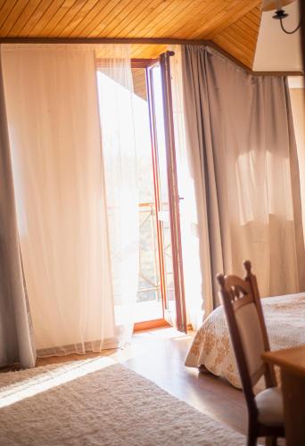 a bedroom with a bed and a large window at Bogolvar Retreat Resort in Antonovka