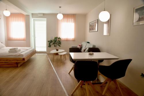 ein Wohnzimmer mit einem Bett, einem Tisch und Stühlen in der Unterkunft Mikulov Apartments - Apartmán Radka in Mikulov