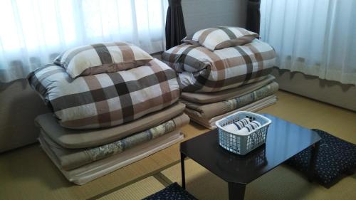 大分的住宿－ゲストハウス小富士，客厅配有2把椅子、枕头和桌子