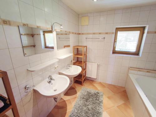 Un baño con dos lavabos y una bañera. en Apartment in Ramsau near Ski Slopes, en Ramsau