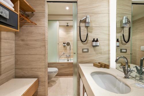 a bathroom with a tub and a toilet and a sink at Precise House Mantegna Roma in Rome