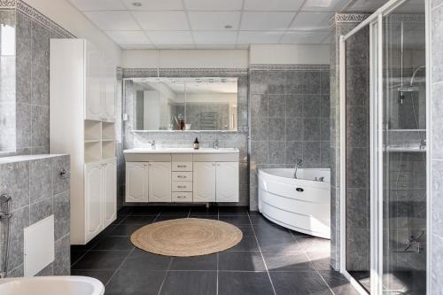 La salle de bains est pourvue d'une baignoire et d'un lavabo. dans l'établissement Large and modern house with 150 meters to sandy beach, à Rydaholm