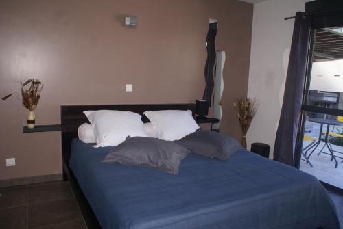 1 dormitorio con 1 cama con sábanas y almohadas azules en Chambre d’hôte Les Quatres Saisons, en La Plaine des Cafres