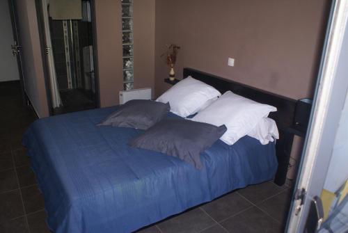 a bedroom with a bed with blue sheets and pillows at Chambre d’hôte Les Quatres Saisons in La Plaine des Cafres