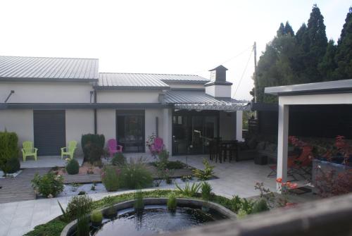 a house with a pond in the yard at Chambre d’hôte Les Quatres Saisons in La Plaine des Cafres