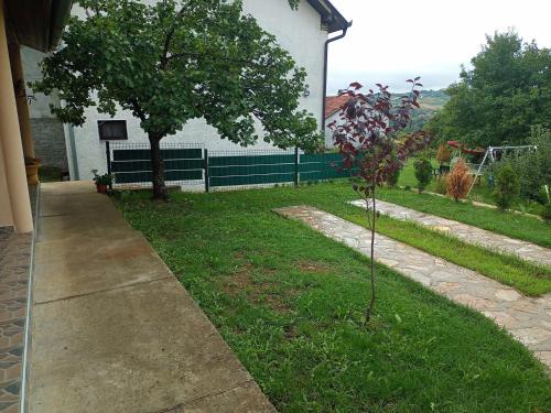 un albero nell'erba vicino a una casa di Smeštaj Vrhovac a Vrdnik