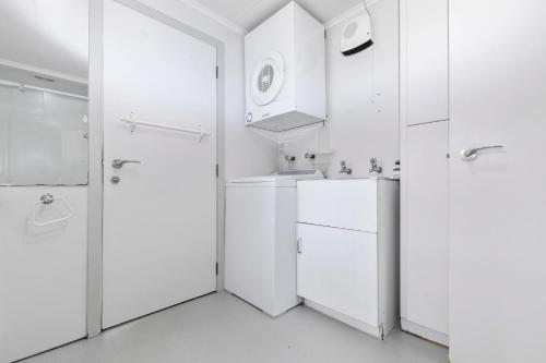 a white bathroom with a sink and a shower at Onepoto Bay Lakehouse - Lake Rotoiti Holiday Home in Okere Falls