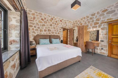 a bedroom with a large bed in a room with stone walls at Villa zeytin patara On the Lycian walking path in Kas