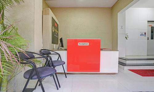 ナーシクにあるTreebo Trend Excellent Homes, Nashikの椅子と赤い箱が備わる部屋