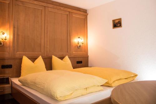 sypialnia z łóżkiem z żółtymi poduszkami w obiekcie Appartement Paulis Hof w mieście Ischgl