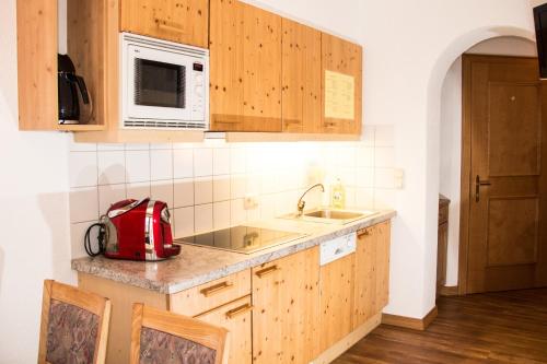 kuchnia z drewnianymi szafkami i czerwonym urządzeniem w obiekcie Appartement Paulis Hof w mieście Ischgl