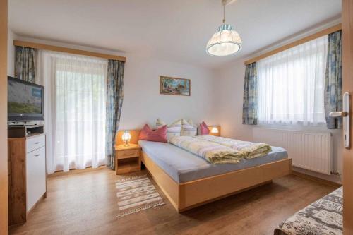 1 dormitorio con 1 cama, TV y ventanas en Ferienwohnungen Mischbach, en Neustift im Stubaital