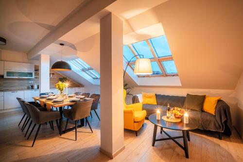 een woonkamer en een keuken met een tafel en een bank bij Centrum Apartments Pstrossova in Praag