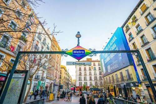 un letrero de la calle en medio de una ciudad en Woohoo Rooms Chueca, en Madrid